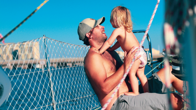 A man holding a baby on a yacht